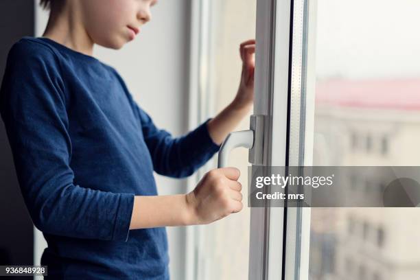 boy trying to open the window pulling its handle - open day 6 fotografías e imágenes de stock