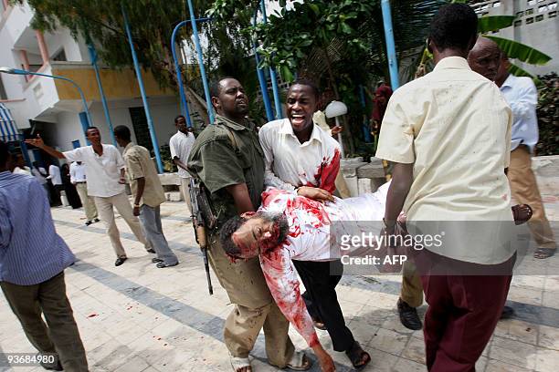 The body of the Somali Minister of Education Ibrahim Hassan Cadow is carried away from the scene of a suicide bomb attack during a university student...