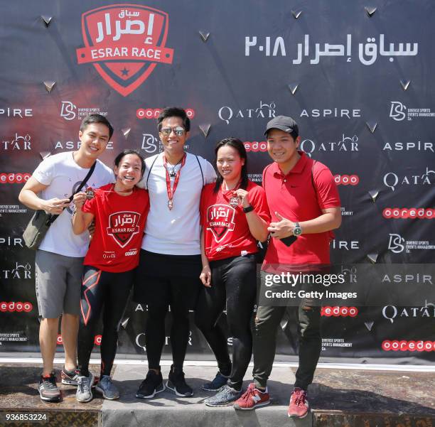 Competitors celebrate after completing the Esrar Obstacle Course Race at Aspire Park on March 23, 2018 in Doha, Qatar.