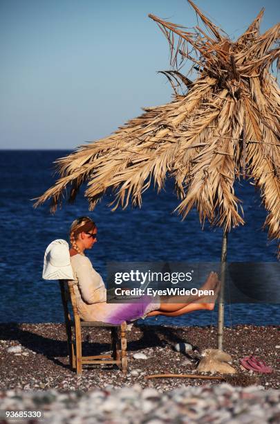 Woman on a beach working with a notebook near Lindos on July 16, 2009 in Rhodes, Greece. Rhodes is the largest of the Greek Dodecanes Islands.