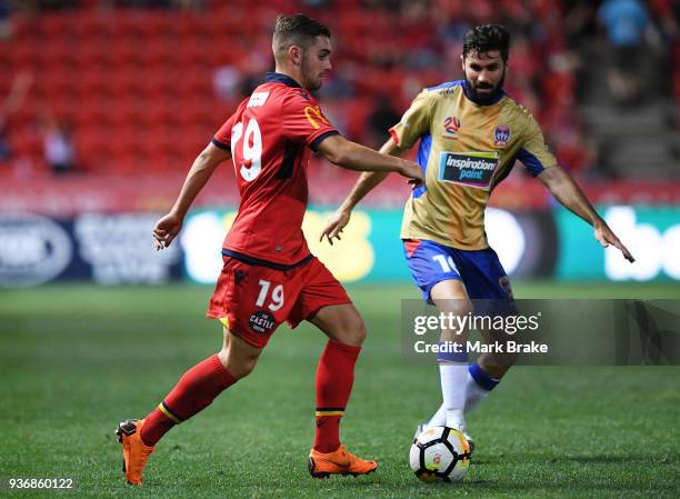 Ben Garuccio of Adelaide United gets past Nick Cowburn of the Newcastle Jets during the round 24 A-League match between Adelaide United and the...