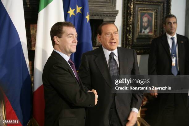 Russian President Dmitry Medvedev shakes hands with Italian Prime Minister Silvio Berlusconi while attending a meeting at Villa Madama on December 3,...