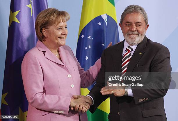 Brazilian President Luiz Inacio Lula da Silva and German Chancellor Angela Merkel shake hands after speaking to the media following talks on December...