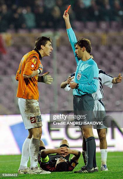 Referee Paolo Tagliavento gives a red card to goalkeeper Costel Pantilimon of FC Timisoara during UEFA Europa League group A football match against...