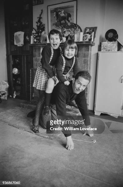 British jockey Lester Piggott with his daughters Tracey and Maureen, at his Newmarket home, Suffolk, UK, 19th December 1968.