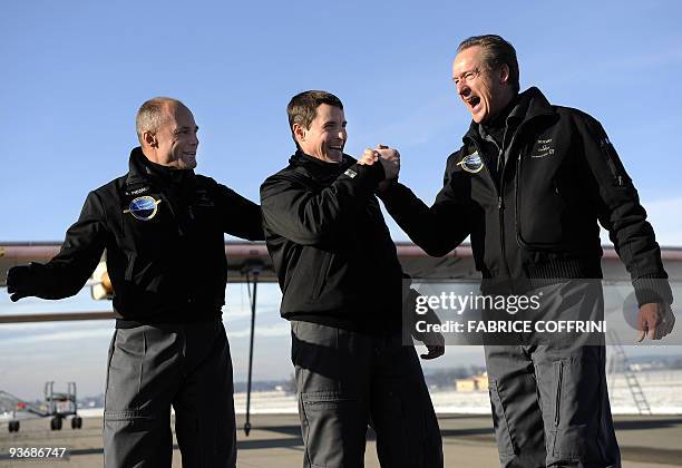 Swiss scientist-adventurer and pilot Bertrand Piccard test pilot Markus Scherdel and Solar Impulse CEO Andre Borschberg react after the aircraft...