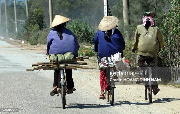 Vietnam-energy-oil-resources-development, by Peter Stebbings Three recyclable item collecting women cycle home on a road at Dung Quat industrial zone...