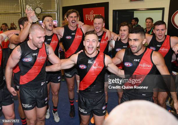 Jake Stringer, Devon Smith and Adam Saad of the Bombers are sprayed with drinks as the Bombers sing the song in the rooms after winning the round one...