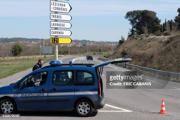 French gendarmes block the access to Trebes, where a man took hostages at a supermarket on March 23, 2018 in Trebes, southwest France. At least one...