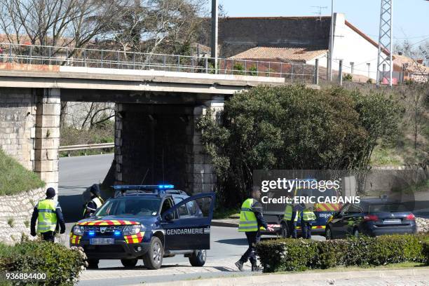 French gendarmes block the access to Trebes, where a man took hostages at a supermarket on March 23, 2018 in Trebes, southwest France. At least two...