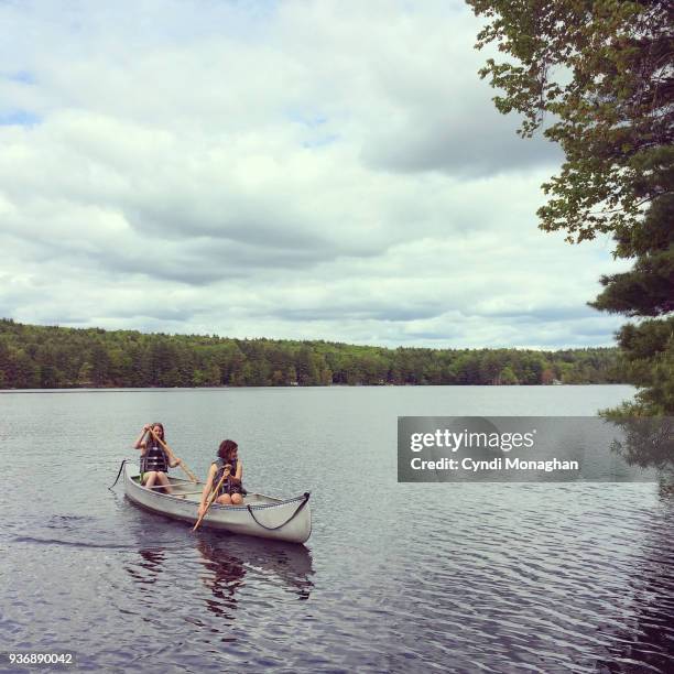 young girls canoeing - girl rowing boat photos et images de collection