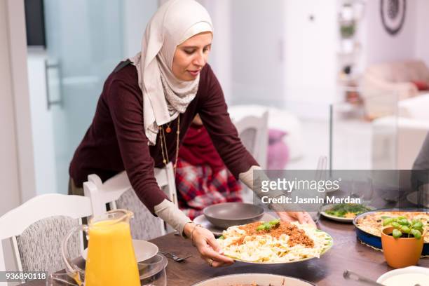 Muslim woman serving food at home