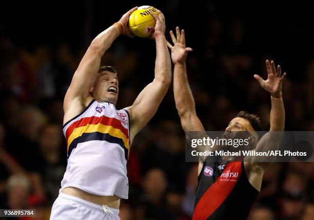 Josh Jenkins of the Crows marks the ball over Matt Dea of the Bombers during the 2018 AFL round 01 match between the Essendon Bombers and the...
