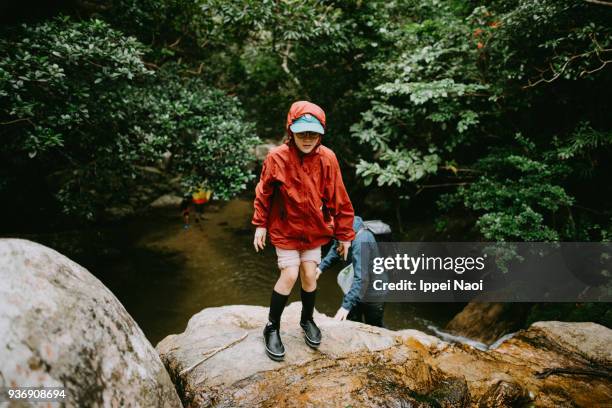 Pre-teen girl trekking in jungle river in rain, Ishigaki Island, Okinawa, Japan