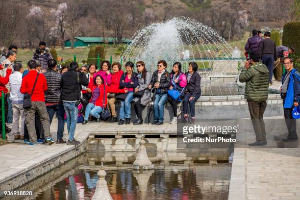 Group of Singaporean tourists pose for a picture in the Tulip garden during spring season on March 23, 2018 in Srinagar, the summer capital of Indian...