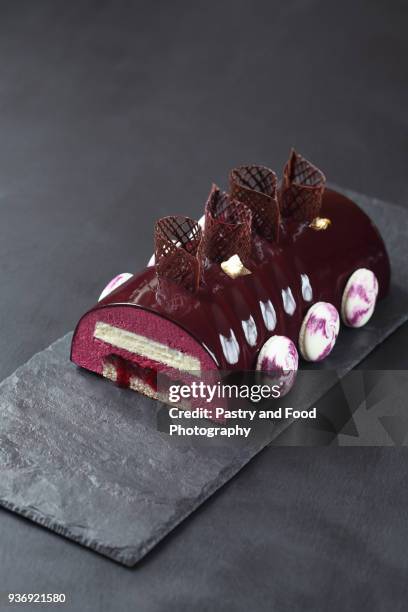 contemporary black currant chocolate yule log - christmas log stock-fotos und bilder