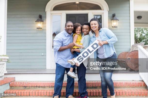 familia orgullosa de su nuevo hogar - estrenar casa fotografías e imágenes de stock