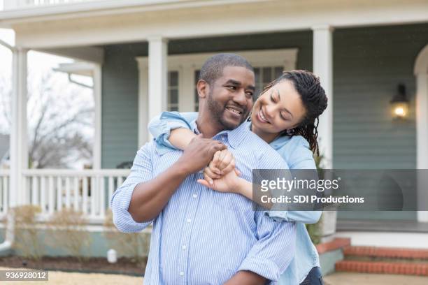 attractive african american couple in front of their home - ethereal building stock pictures, royalty-free photos & images