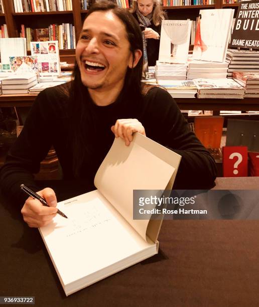 Belgian fashion designer Olivier Theyskens laughs as he signs a copy of his book, 'She Walks In Beauty,' during an event at Rizzoli Bookstore, New...