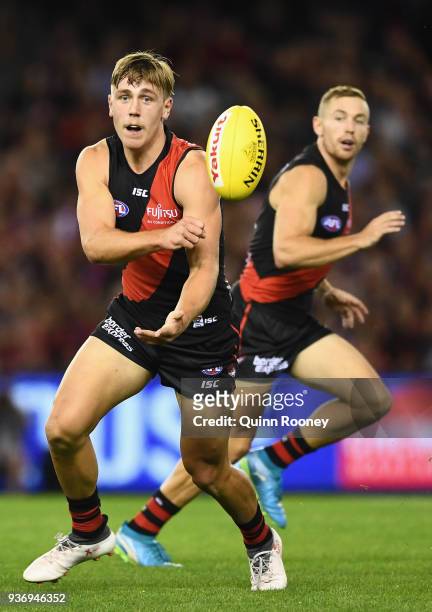 Joshua Begley of the Bombers handballs during the round one AFL match between the Essendon Bombers and the Adelaide Crows at Etihad Stadium on March...