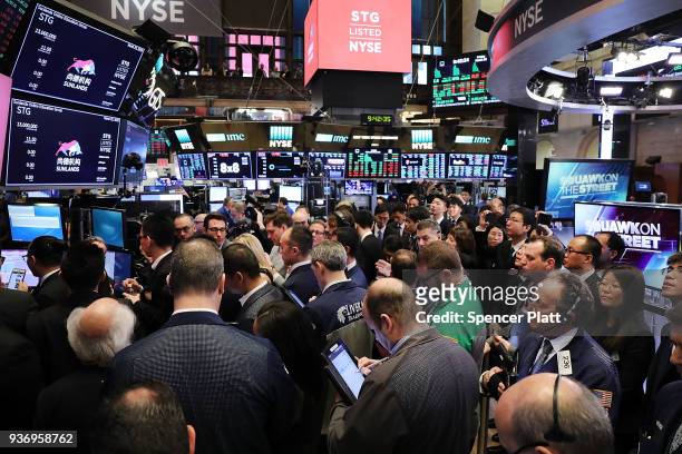 Traders and employees of Sunlands Online Education gather on the floor of the New York Stock Exchange during the Beijing-based firms IPO on March 23,...
