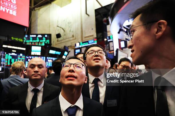 Traders and employees of Sunlands Online Education gather on the floor of the New York Stock Exchange during the Beijing-based firms IPO on March 23,...