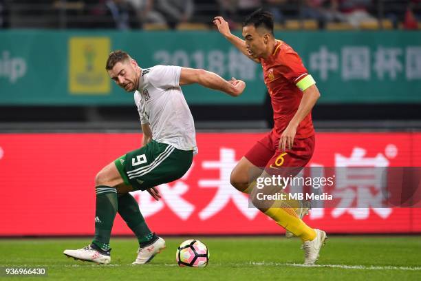 Feng Xiaoting, right, of Chinese national men's football team kicks the ball to make a pass against Sam Vokes of Wales national football team in the...