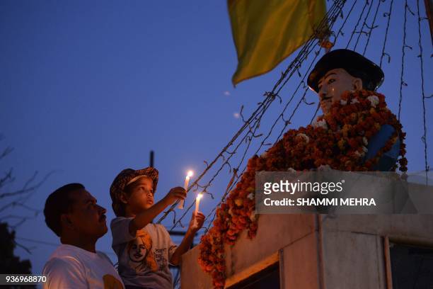 An Indian child pays tribute to the revolutionary Bhagat Singh at his statue to mark his death anniversary in Jalandhar on March 23, 2018. Singh, who...