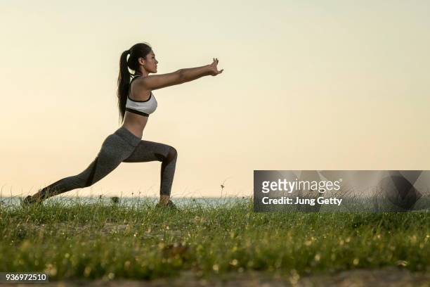 young asian models yoga. beautiful teenage girl in sports clothing training yoga position on the mat the beach during sunset time - oriental asiático e indio fotografías e imágenes de stock