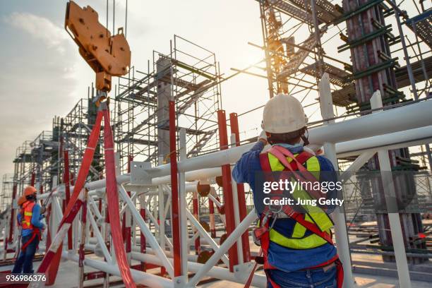 working at height equipment. fall arrestor device for worker with hooks for safety body harness on selective focus. worker as a background. - construction contract stock pictures, royalty-free photos & images