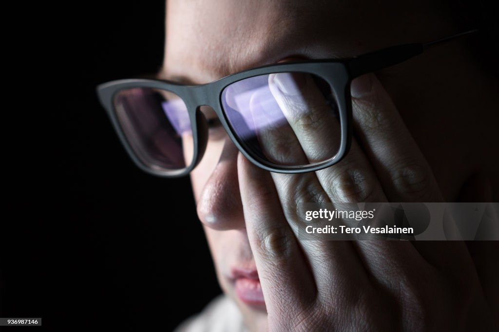 Man rubbing tired eyes. Problem with glasses, eyesight or vision. Person having stress or depression. Workplace bullying. Working late with computer.