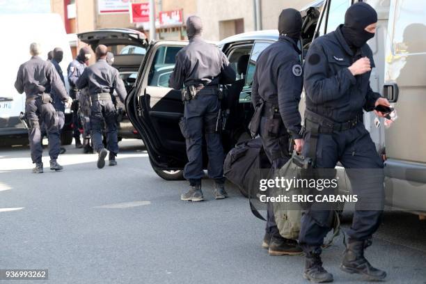 French National Gendarmerie Intervention Group stand next to vehicles as they gather outside the Super U supermarket in the town of Trebes, southern...
