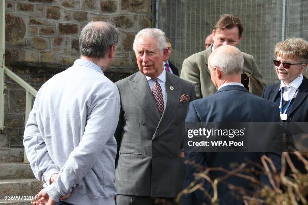 Prince Charles, Prince of Wales is accompanied by Governer Bridie Oakes-Richard as he speaks to Horticultural Instructor James Gearing and a prisoner...