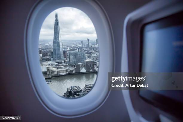 picture taken from airplane window traveling around the world from the airplane with london view. - plane windows stock pictures, royalty-free photos & images