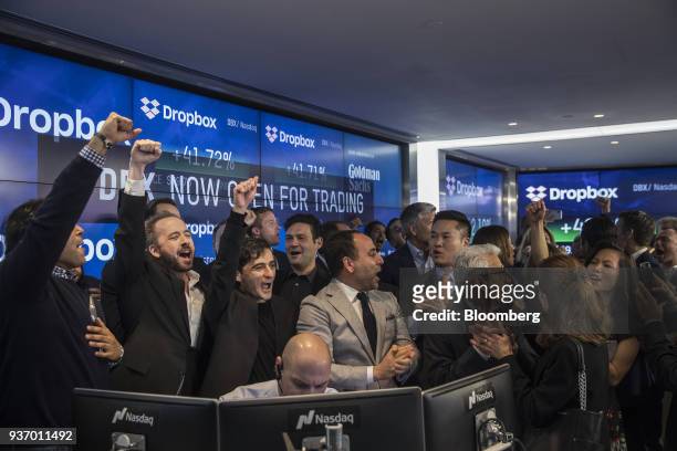 Drew Houston, chief executive officer and co-founder of Dropbox Inc., second left, and Arash Ferdowsi, co-founder of Dropbox Inc., third left, react...