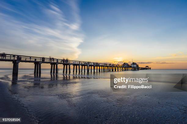 pôr do sol ao longo do cais de nápoles na flórida da praia - naples pier florida - fotografias e filmes do acervo