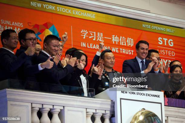 Peng Ou, founder of Sunlands Online Education Group, center, rings the opening bell during the company's initial public offering on the floor of the...