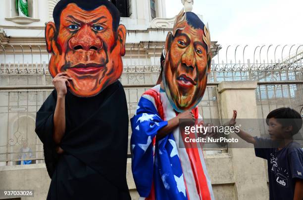 Child gives one of the activists in Duterte masks a high five. Various groups gather at Plaza Mirada on March 23, 2018 for a lent-themed...