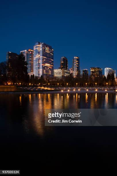city of bellevue at night with city lights reflected in small pond at downtown park, washington state - bellevue washington state stock pictures, royalty-free photos & images