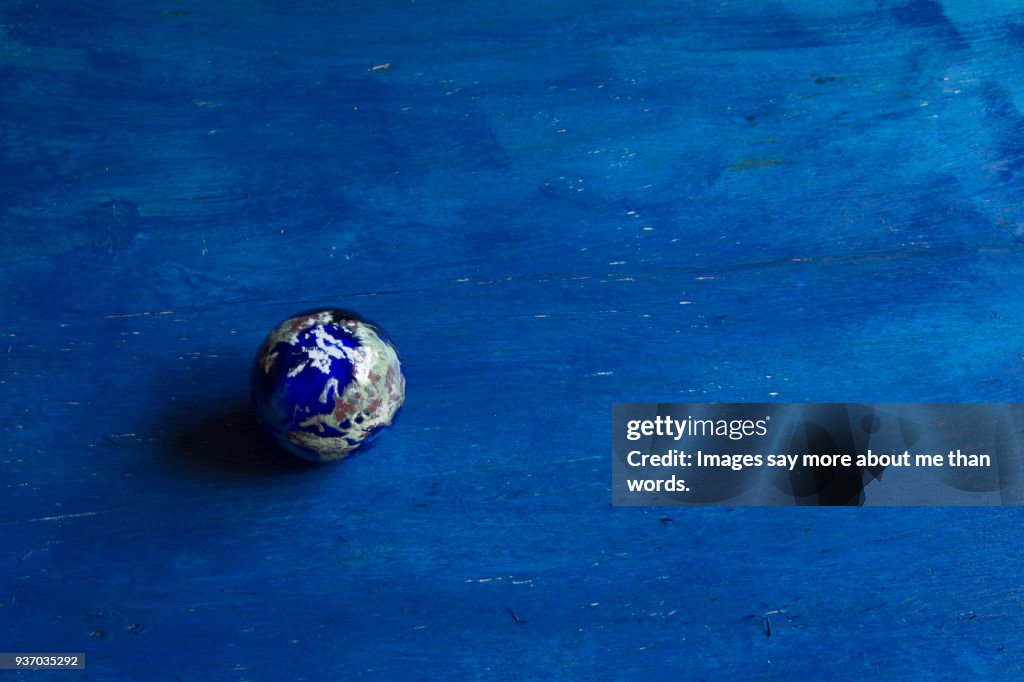 A paper weight in planet Earth style on blue background.