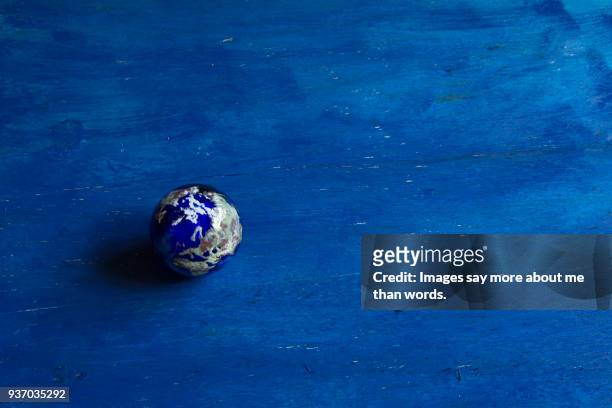 a paper weight in planet earth style on blue background. - biosphere planet earth stock pictures, royalty-free photos & images