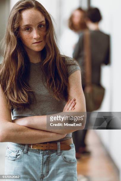 een tiener schoolmeisje is serieus kijken naar de camera. eenzaamheid en verdriet - child standing talking stockfoto's en -beelden