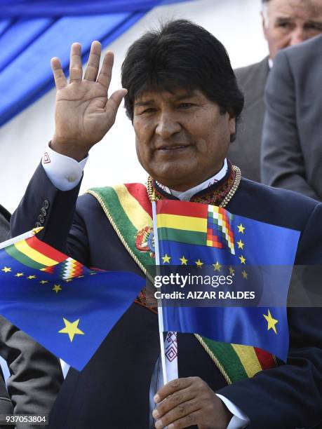 Bolivian President Evo Morales waves as he holds a so-called "flag of maritime revindication" during the commemoration of the 139th anniversary of...