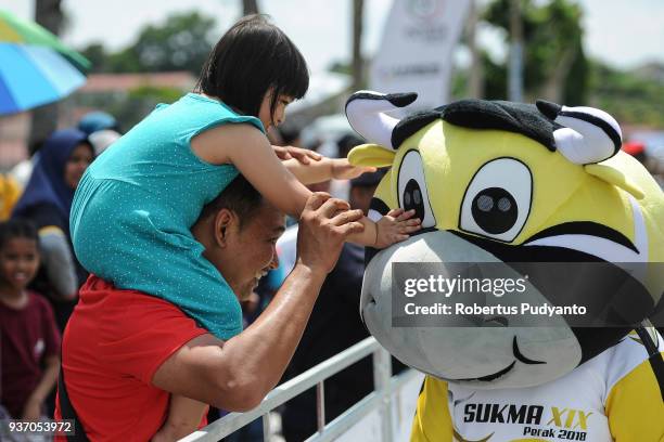 Malaysian girl plays with Sukma XIX 2018 mascot during Stage 6 of the Le Tour de Langkawi 2018, Tapah-Tanjung Malim 108.5 km on March 23, 2018 in...