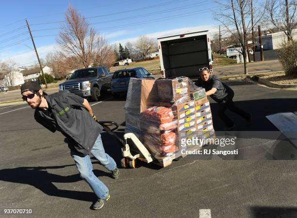 Drew Sanford, left, and Rani Piece, both employee at We Don't Waste, arrive with food for a church food bank in Federal Heights on March 23, 2018 in...