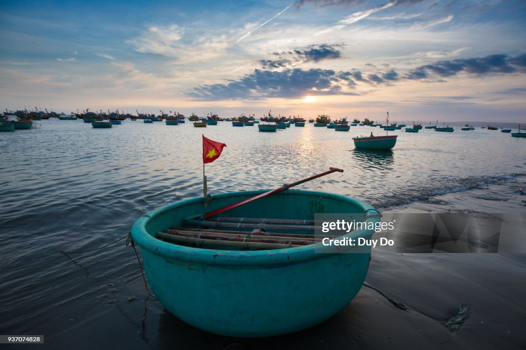 Floating fishing boat with Vietnamese flag in Mui Ne village, Phan Thiet, Vietnam