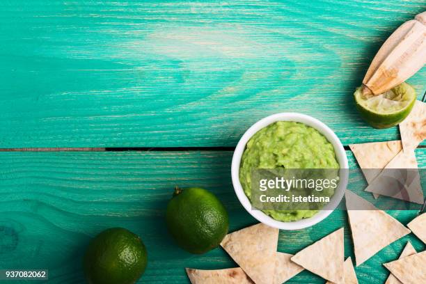 fresh guacamole dip with lime juice and tortilla chips - tortilla chip stock-fotos und bilder
