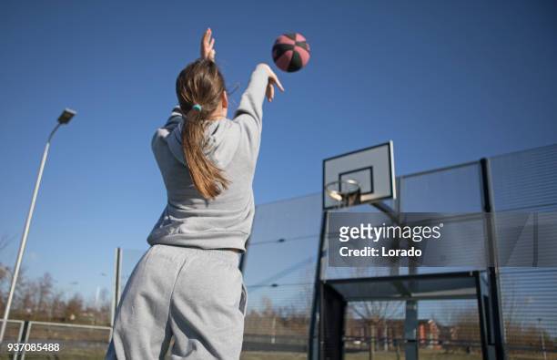 sessão de treinamento de basquete urbano ao ar livre para o jogador de streetball individual feminino adolescente - arremesso de jump no basquetebol - fotografias e filmes do acervo