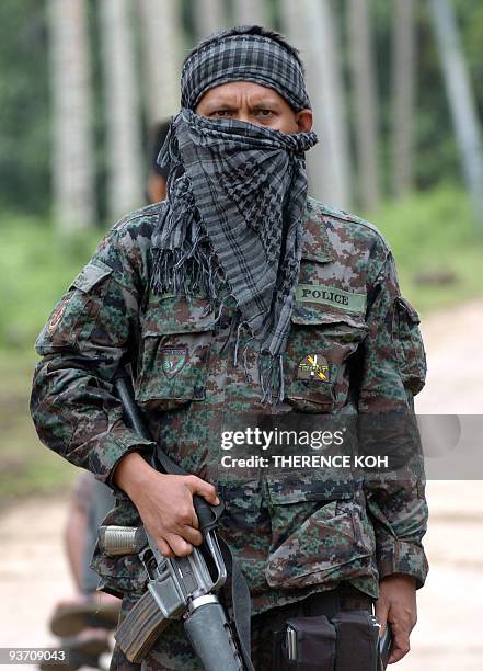 Armed policemen are deployed along the road in Indanan town in southern Jolo island on February 12, 2009. Civilians have been ushered out of the area...