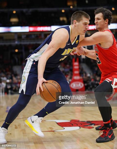 Nikola Jokic of the Denver Nuggets drives against Paul Zipser of the Chicago Bulls at the United Center on March 21, 2018 in Chicago, Illinois. The...